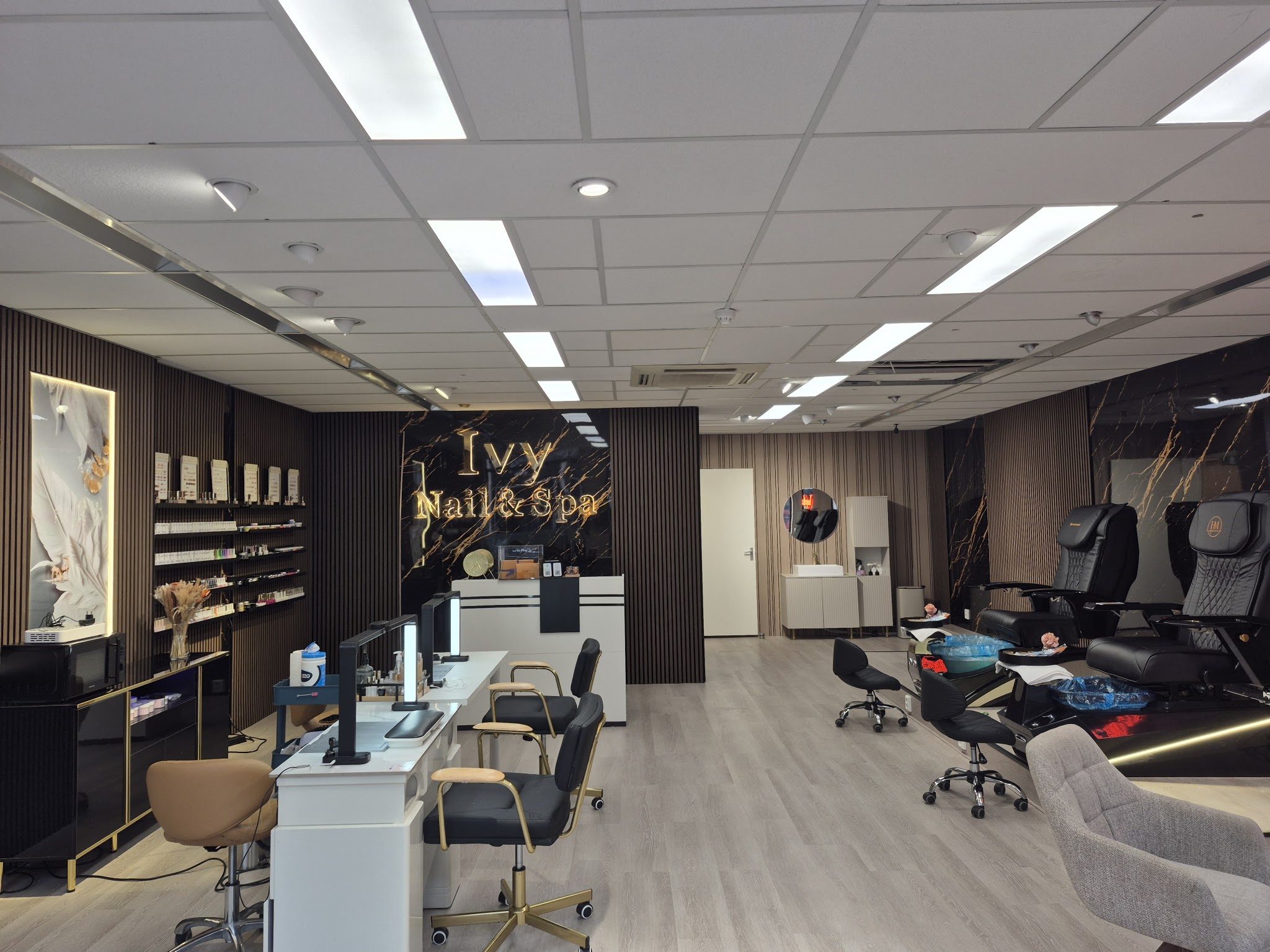 De salon met de marmeren wand, het gouden naambord en de manicuretafels